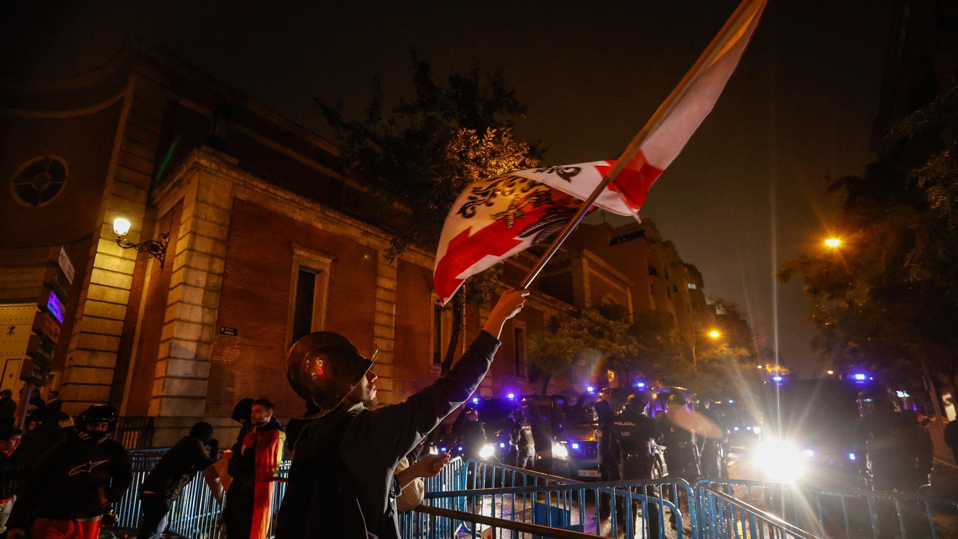 Varias personas portan banderas, durante una protesta en la calle Ferraz, este viernes por la noche