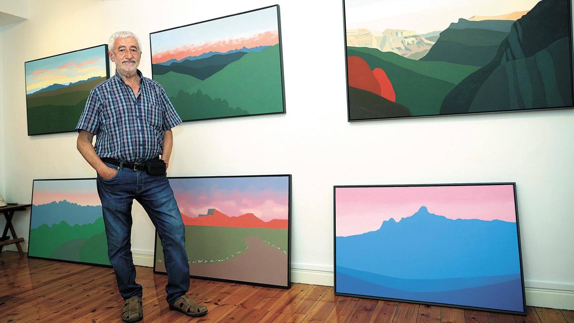 Pedro Salaberri, en su estudio de pintura de Pamplona, junto a algunos paisajes que le caracterizan