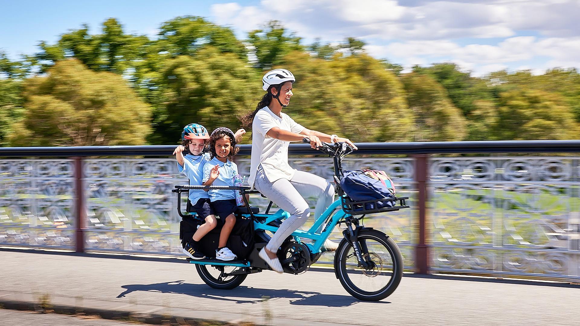 Una mujer lleva a dos menores en una bicicleta eléctrica