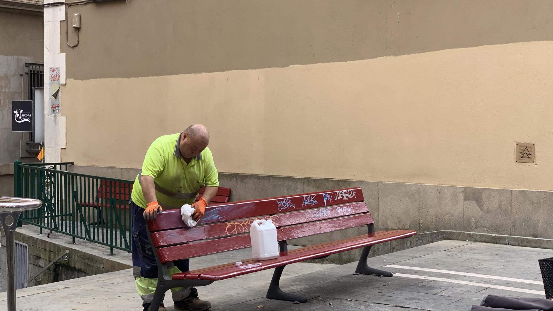 Labores de limpieza de un banco en el Casco Antiguo de Pamplona