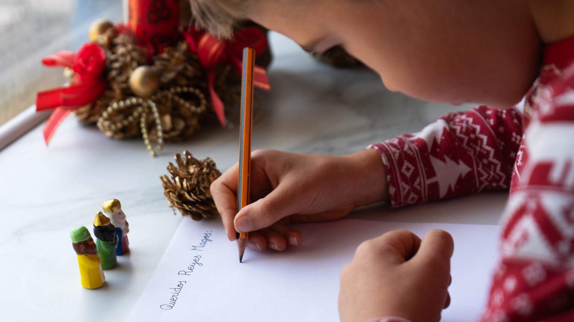Un niño escribe la carta a los Reyes Magos./