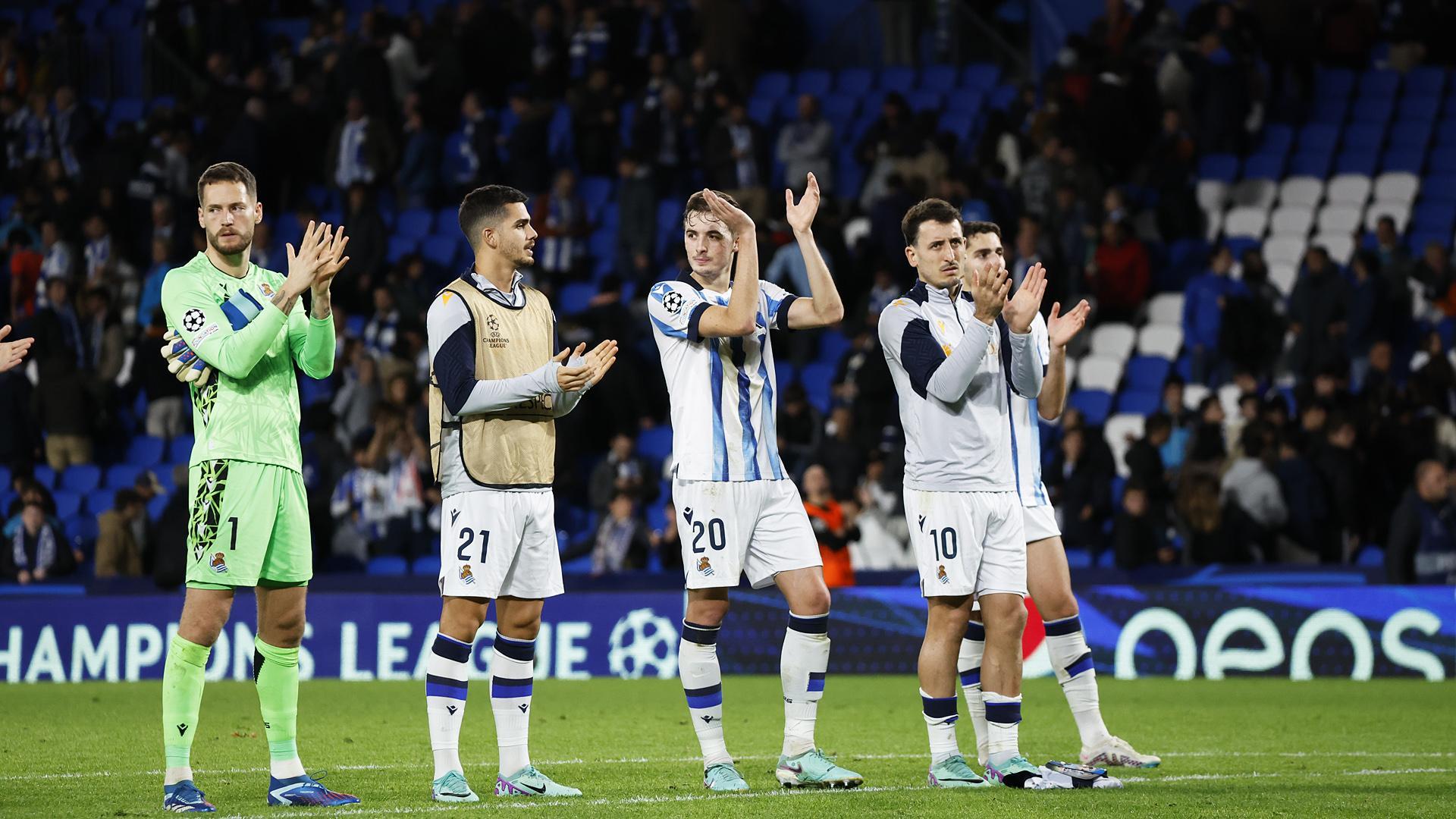 Los jugadores de la Real Sociedad devuelven el apoyo de su público tras el empate contra el Salzburgo./