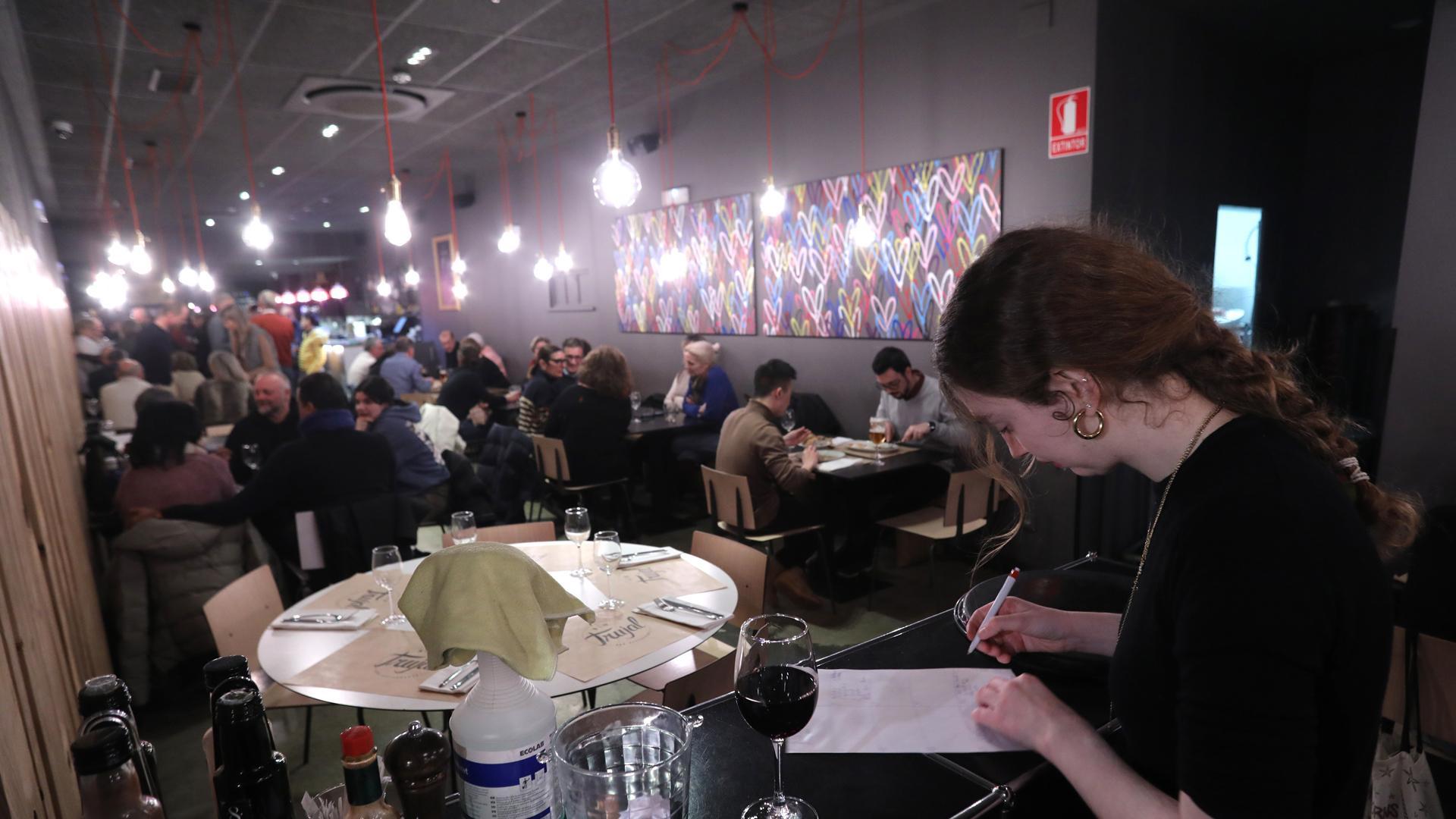 Una camarera del New Trujal, en Pamplona, haciendo anotaciones este viernes con el restaurante abarrotado a la hora de cenar