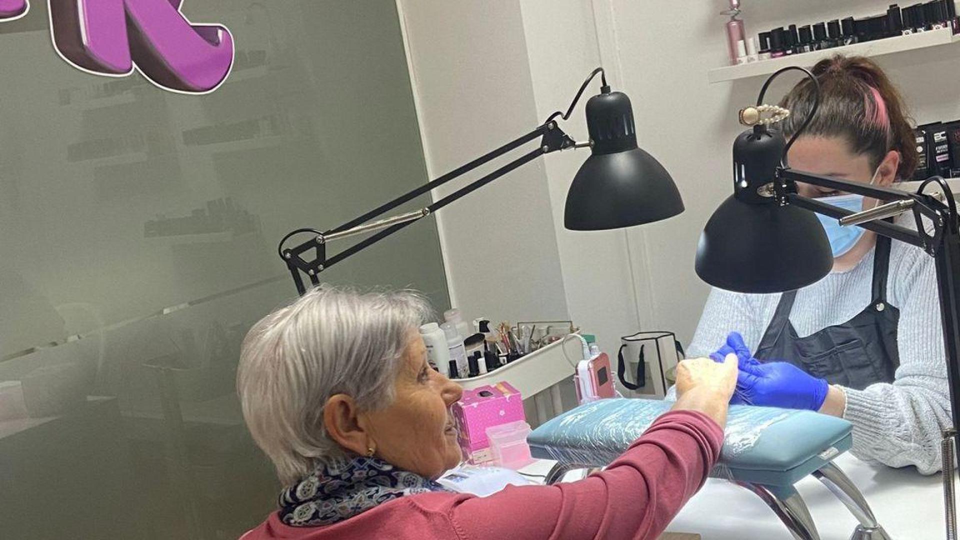 Aránzazu Rodríguez hace la manicura a una clienta en su centro de belleza de la plaza de la Constitución de Burlada