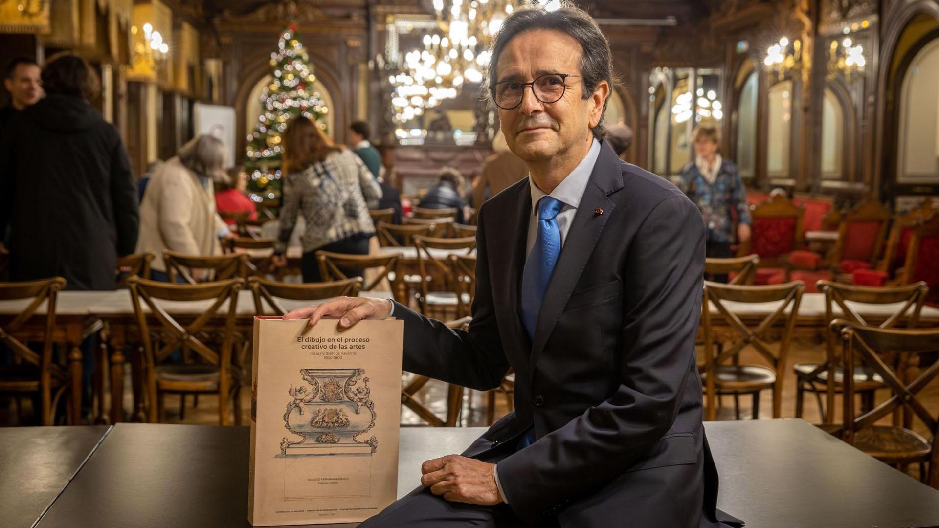 Ricardo Fernández Gracia, director de la monografía, mostrando la portada con el diseño para la peana de San Fermín (1735)