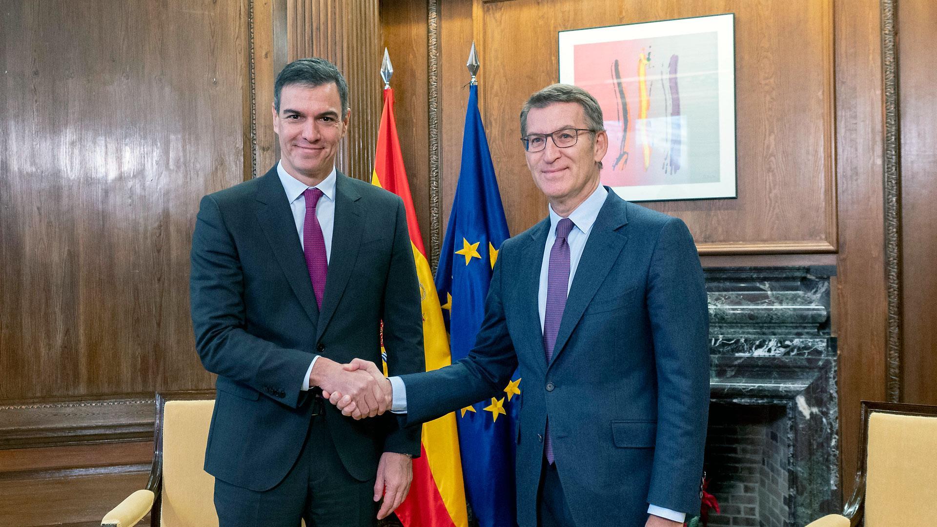 El presidente del Gobierno, Pedro Sánchez (izda.), y el líder del PP, Alberto Núñez Feijóo, se saludan momentos antes de la reunión que han mantenido este viernes en el Congreso de los Diputados