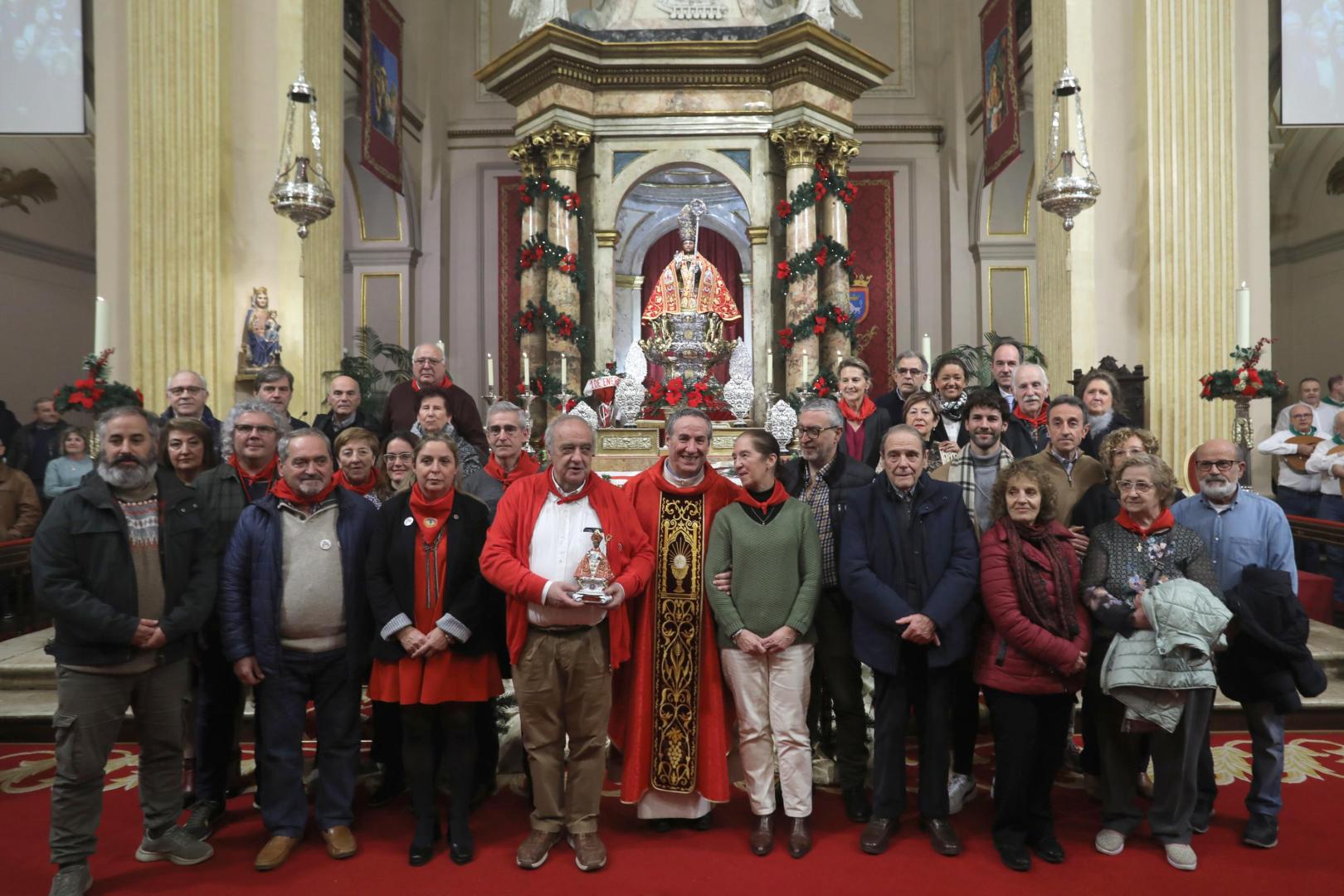 Los integrantes de la asociación posan junto al párroco tras concluir una misa de menos de una hora
