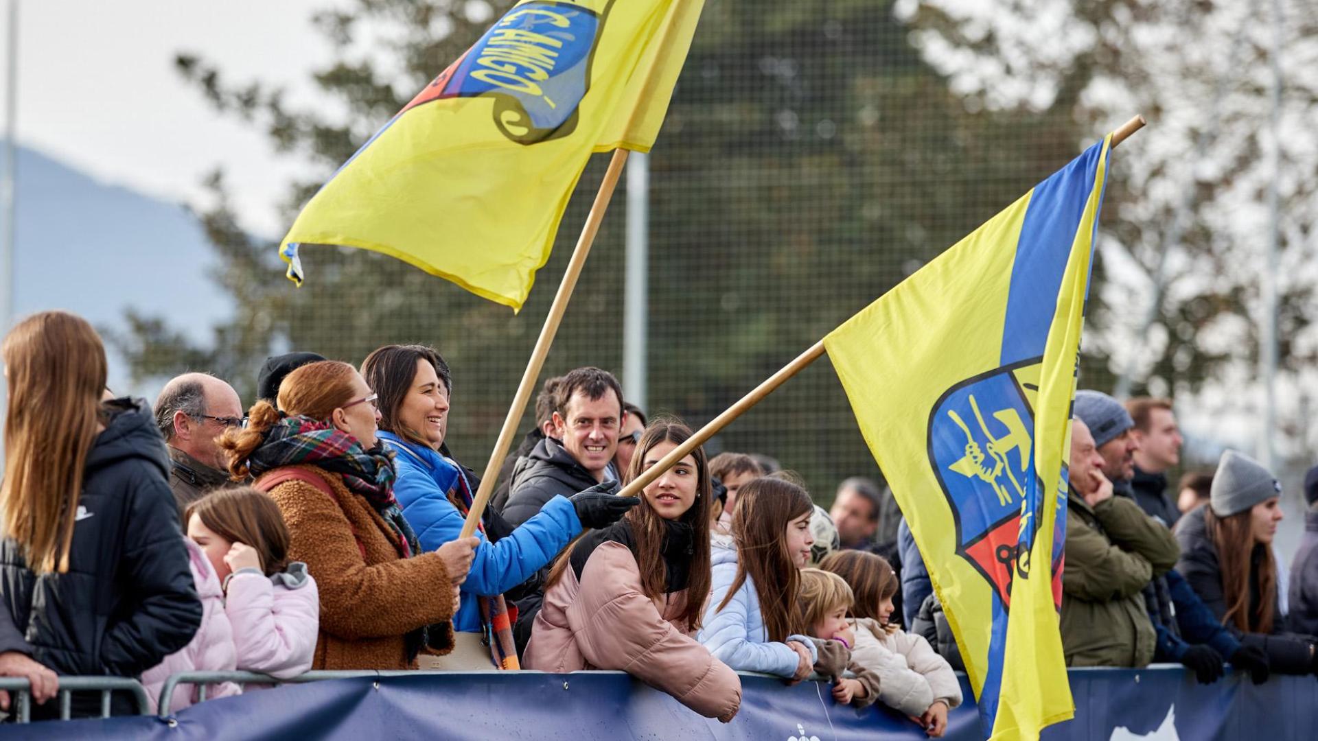 Familiares animan con banderas con el escudo del colegio a los jugadores y jugadoras de Luis Amigó, ayer en las instalaciones de Tajonar