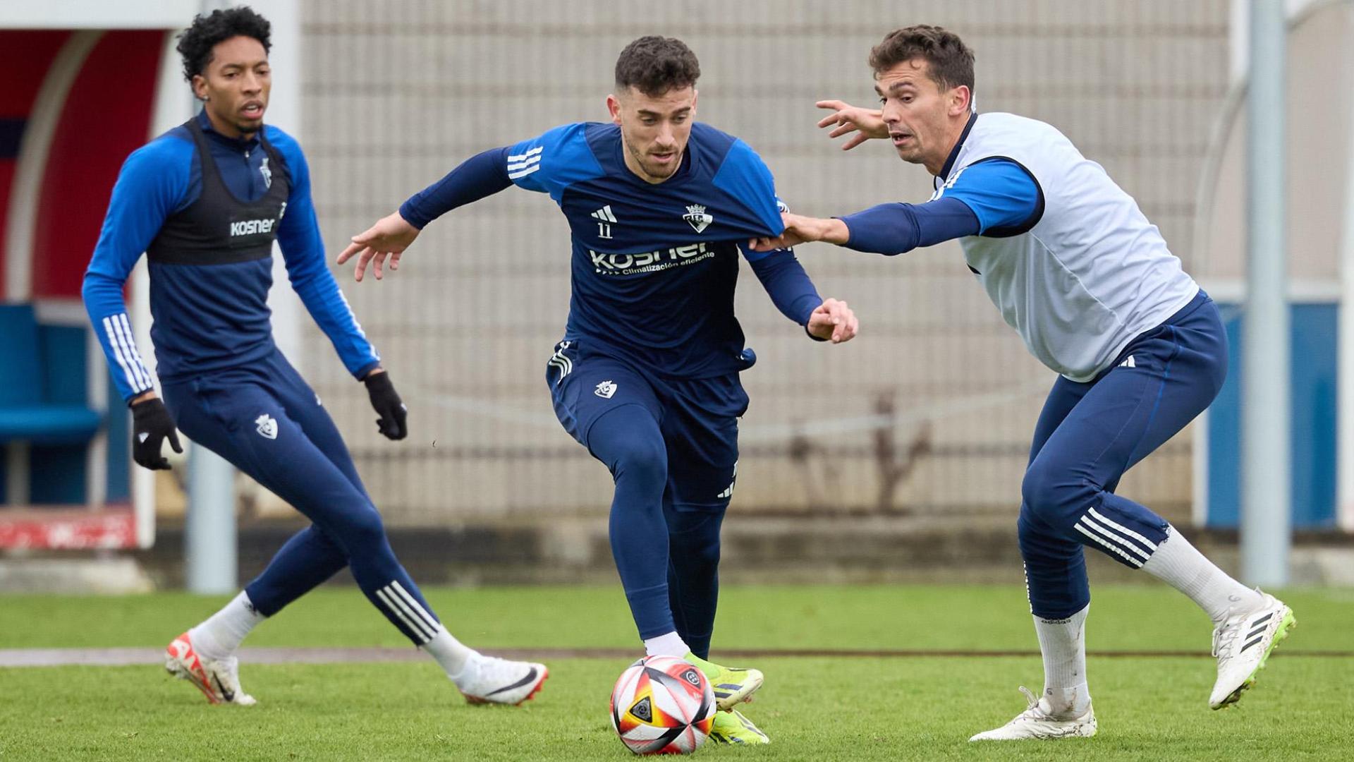Lucas Torró trata de robarle el balón a Kike Barja. Detrás sigue la jugada Mojica, que este viernes completó la sesión junto a sus compañeros