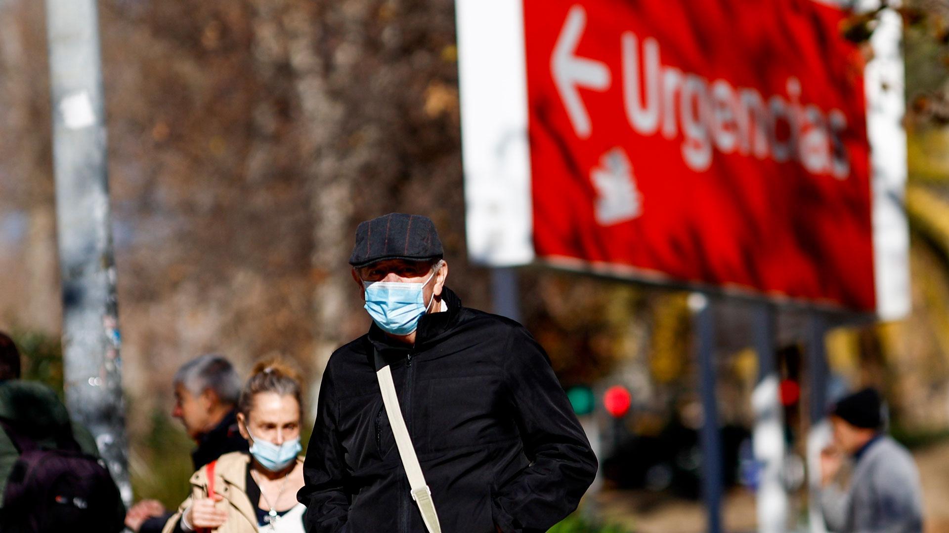 Personas con  mascarillas caminan en el entorno de un centro sanitario en Madrid