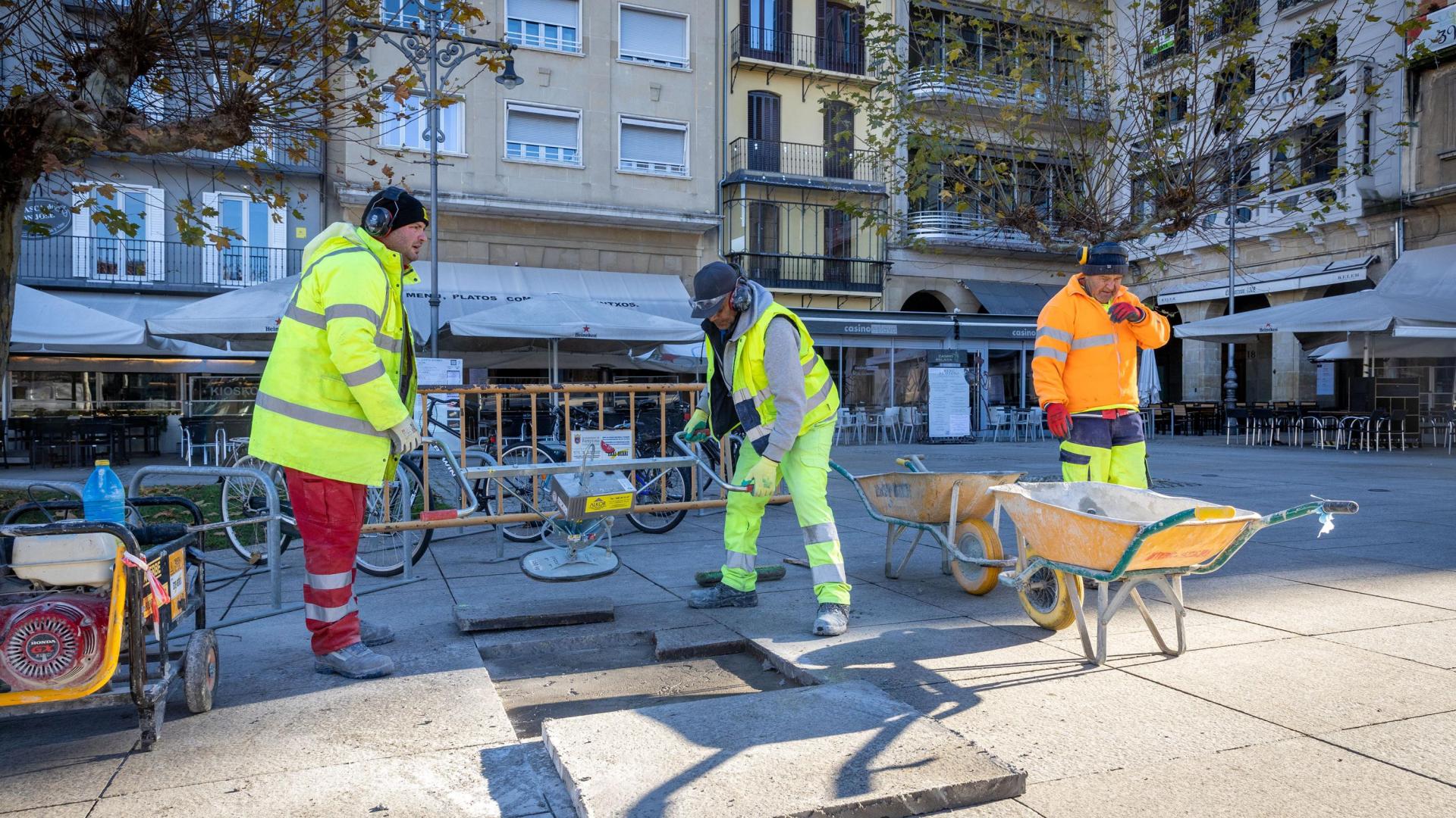 Pravdomir (izquierda), Hassan (en el centro) e Ibrahim (a la derecha) arreglando una de las baldosas de la plaza del Castillo de Pamplona.