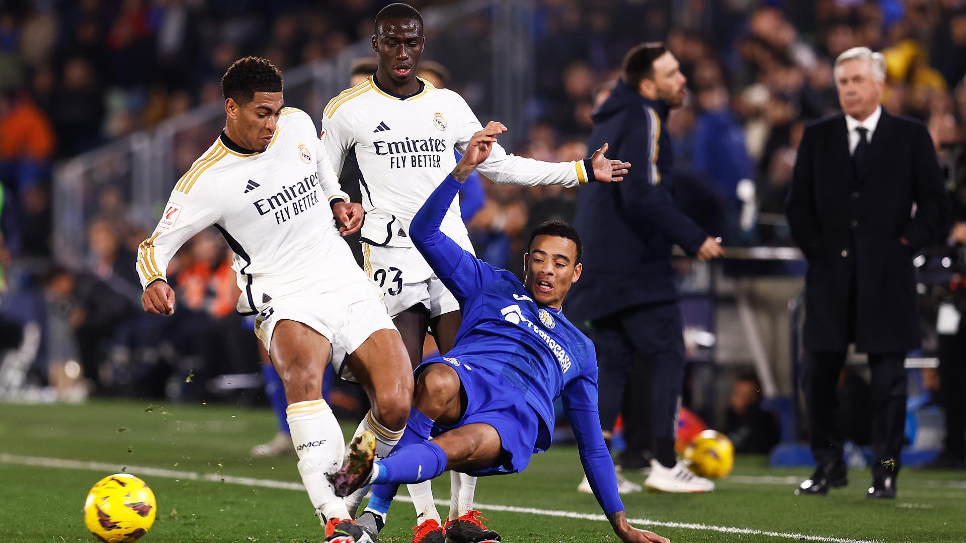 Mason Greenwood trata de golpear el balón ante la presión del madridista Jude Bellingham durante el Getafe-Real Madrid./