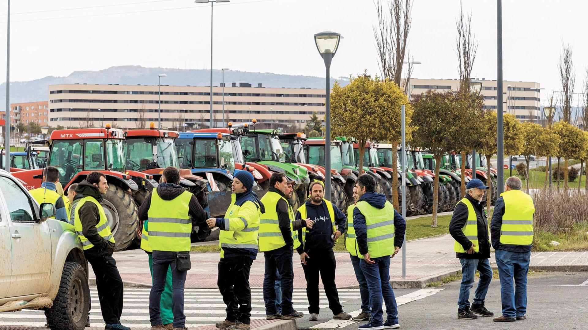 Una quincena de agricultores conversan en Zizur antes de trasladarse al centro de la capital navarra para sumarse a la marcha a pie