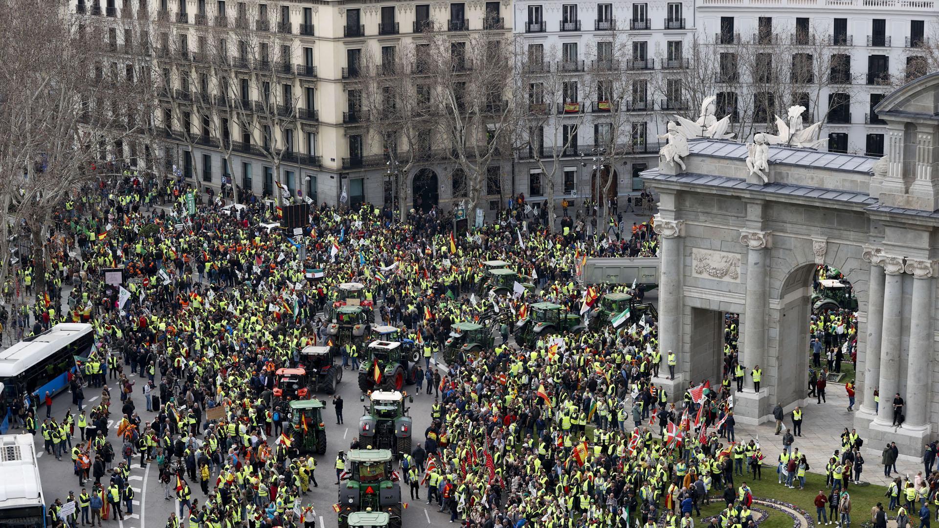 Tractores y manifestantes, este miércoles a su paso por la Puerta de Alcalá, en Madrid
