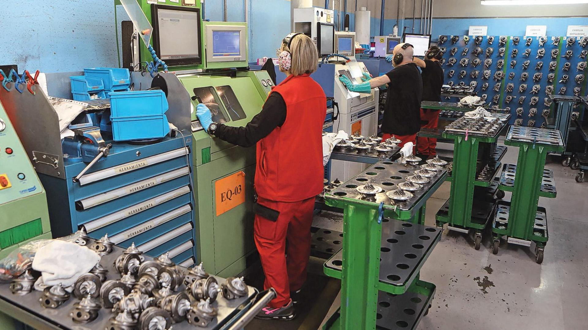 Tres operarios de Borg Automotive en Navarra trabajan en el equilibrado, una de las fases del montaje durante la remanufactura de los turbos