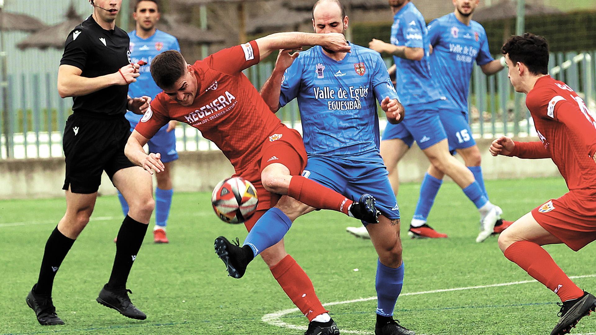 Endika Irigoien, lateral del Izarra, e Imanol Areallano, mediocampista del Valle de Egüés disputan un balón.