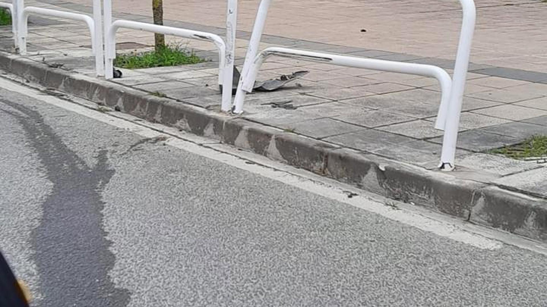 Una de la valla afectada tras la colisión y restos del vehículo tras el accidente.