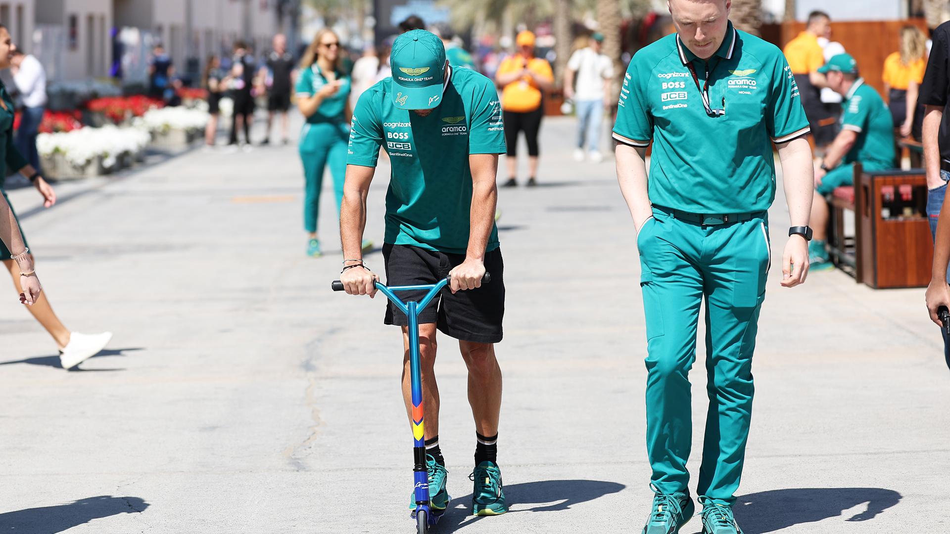 El piloto español Fernando Alonso sobre un patinete en BAhréin.