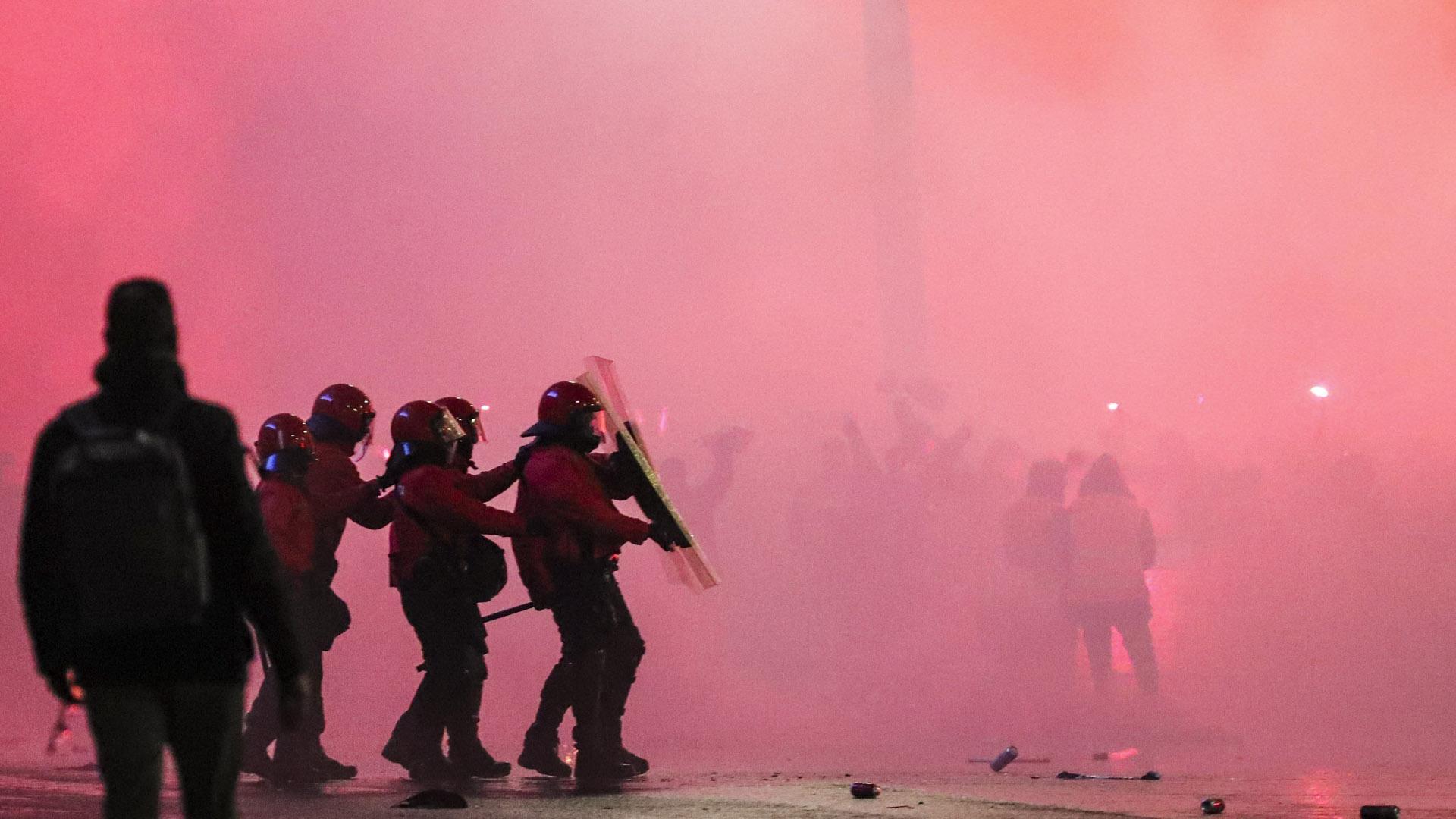 Varios agentes de la Ertzaintza se protegen ante el lanzamiento de objetos en la entrada del estadio San Mamés, momentos antes del partido de vuelta de semifinales de la Copa del Rey