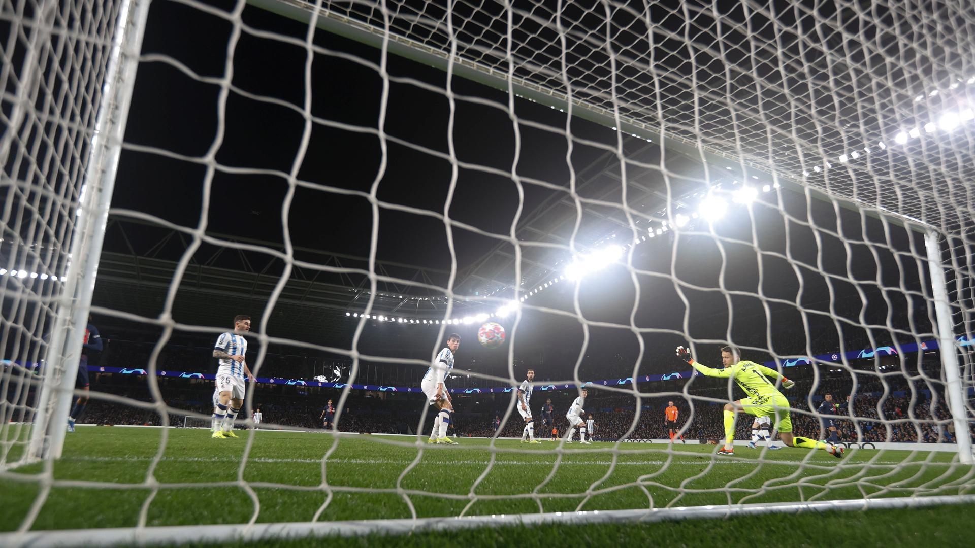 El guardameta de la Real Sociedad, Alex Remiro, intenta detener el remate del delantero del PSG, Kylian Mbappe