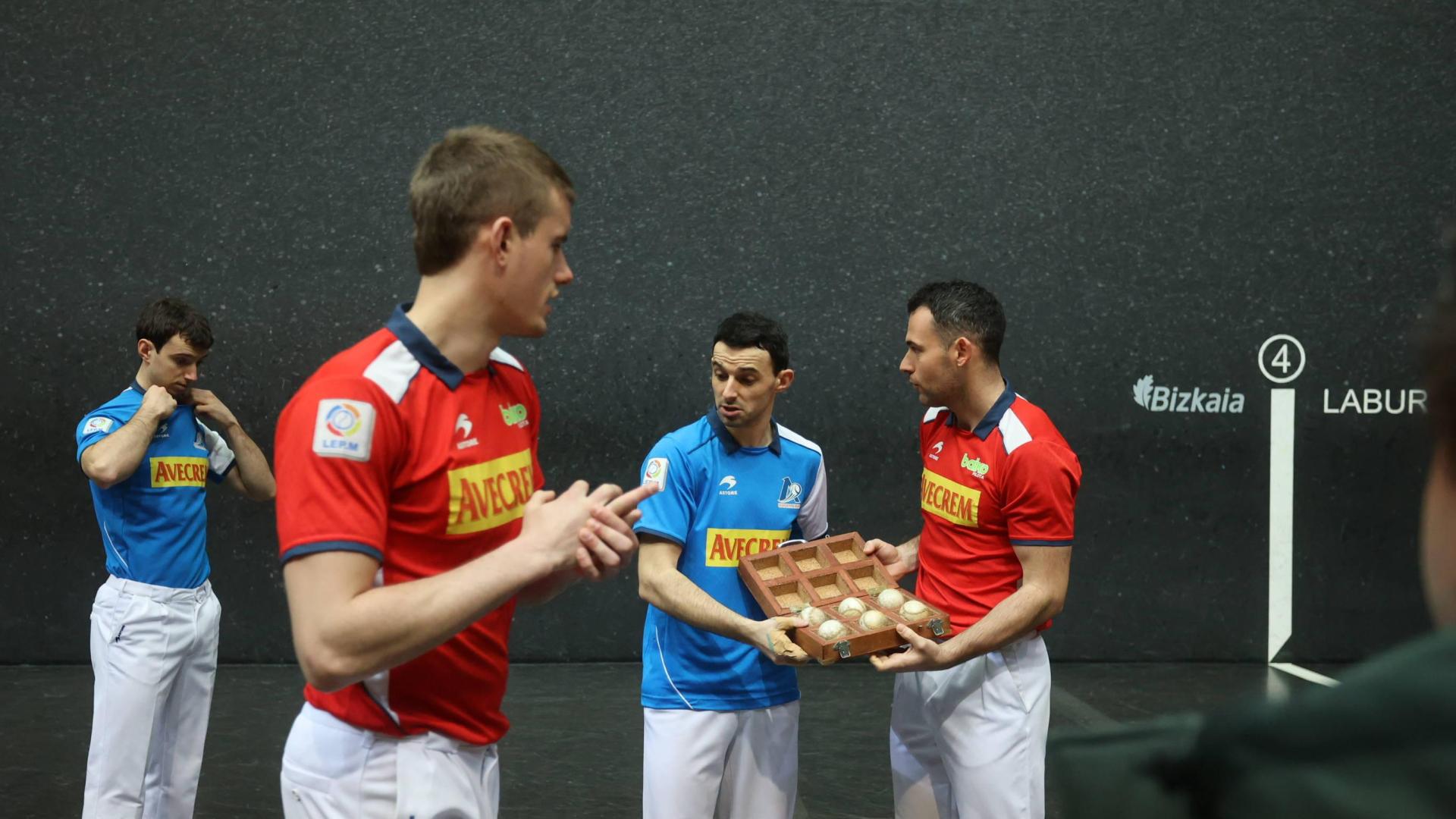 Jokin Altuna y Erik Jaka sostienen el maletín de pelotas mientras sus zagueros se preparan para la foto oficial.