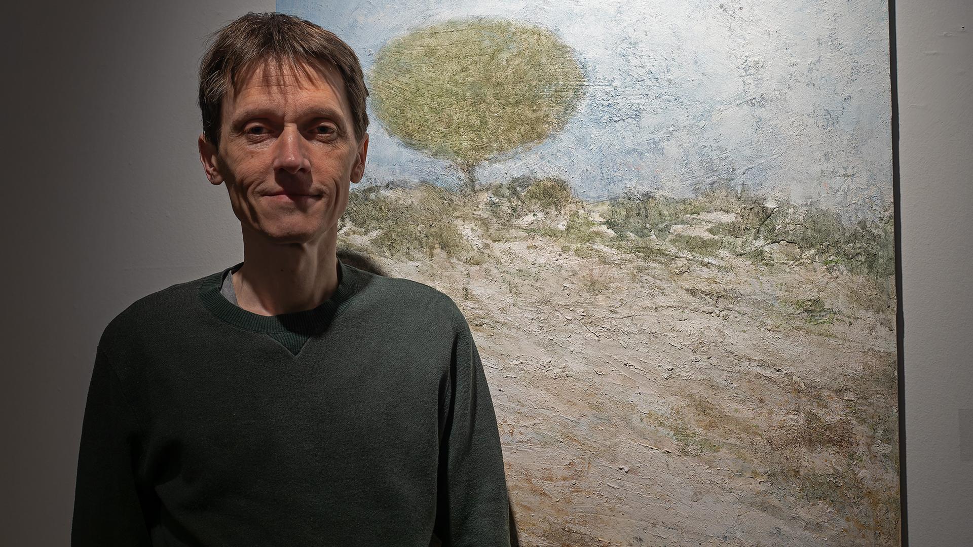 El pintor Carlos López, en el Museo Gustavo de Maeztu junto a una obra de la serie Bardenas