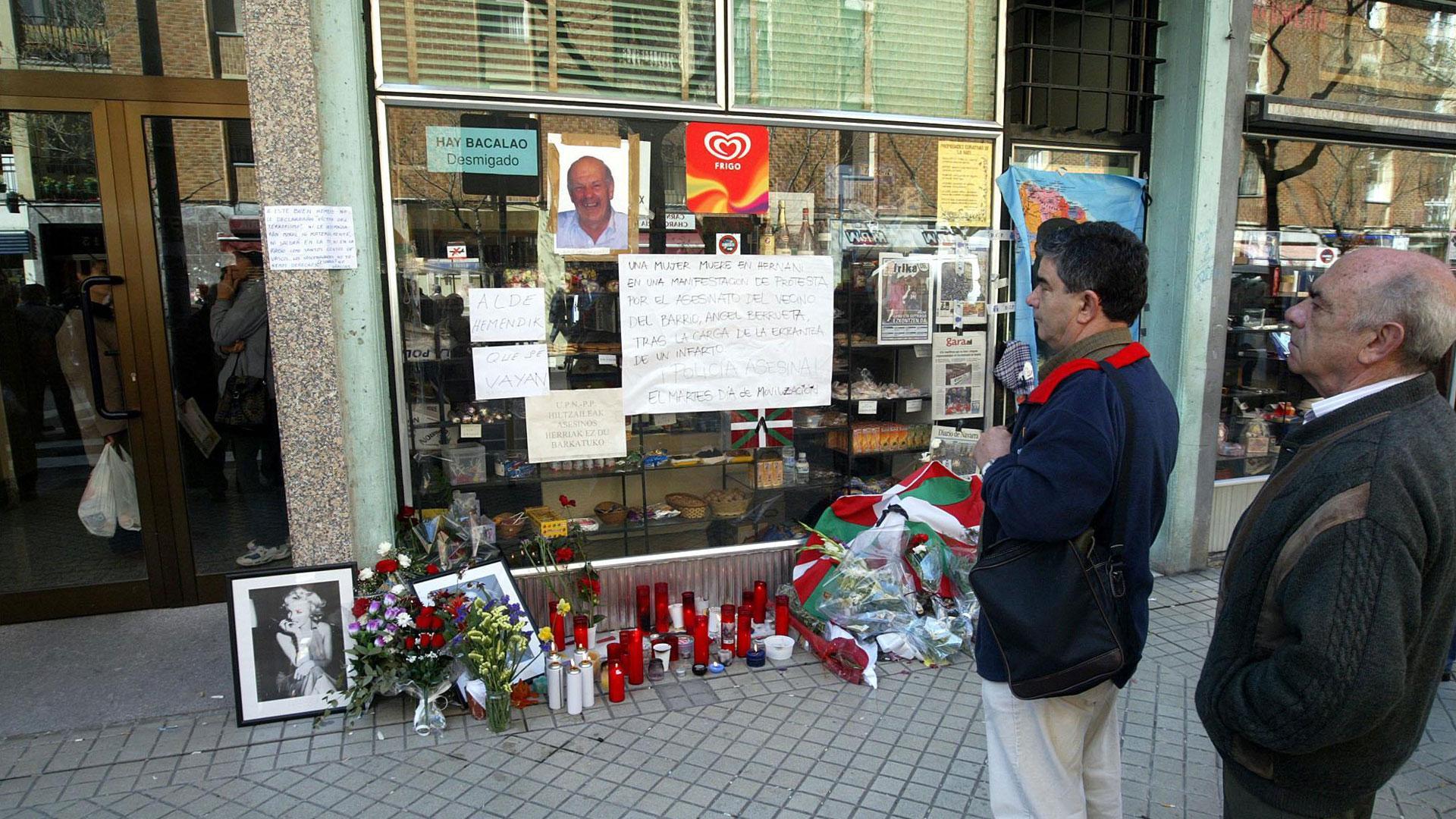Flores, velas y mensajes de apoyo en el escaparate de la tienda de Ángel Berrueta en la calle Martín Azpilicueta tras su asesinato en 2004