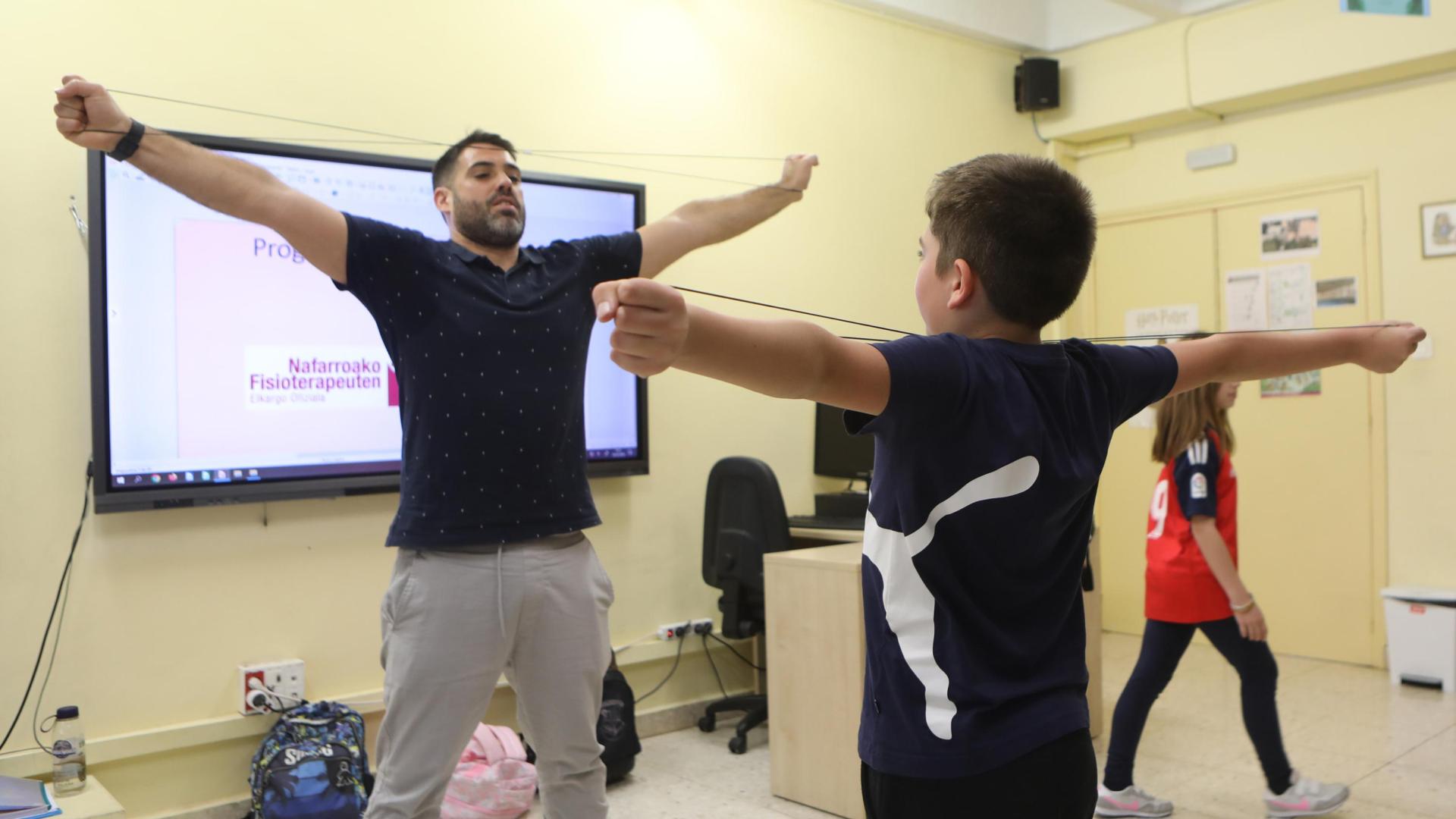 El fisioterapeuta Roberto Martínez practica un ejercicio con un alumno de 4º de Primaria del CP Ermitagaña de Pamplona.