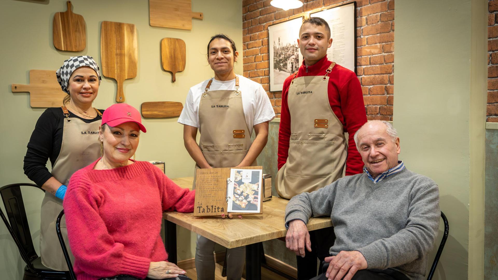 Irina y Raúl, sentados, junto al equipo del restaurante de La Tablita, en la calle Esquíroz