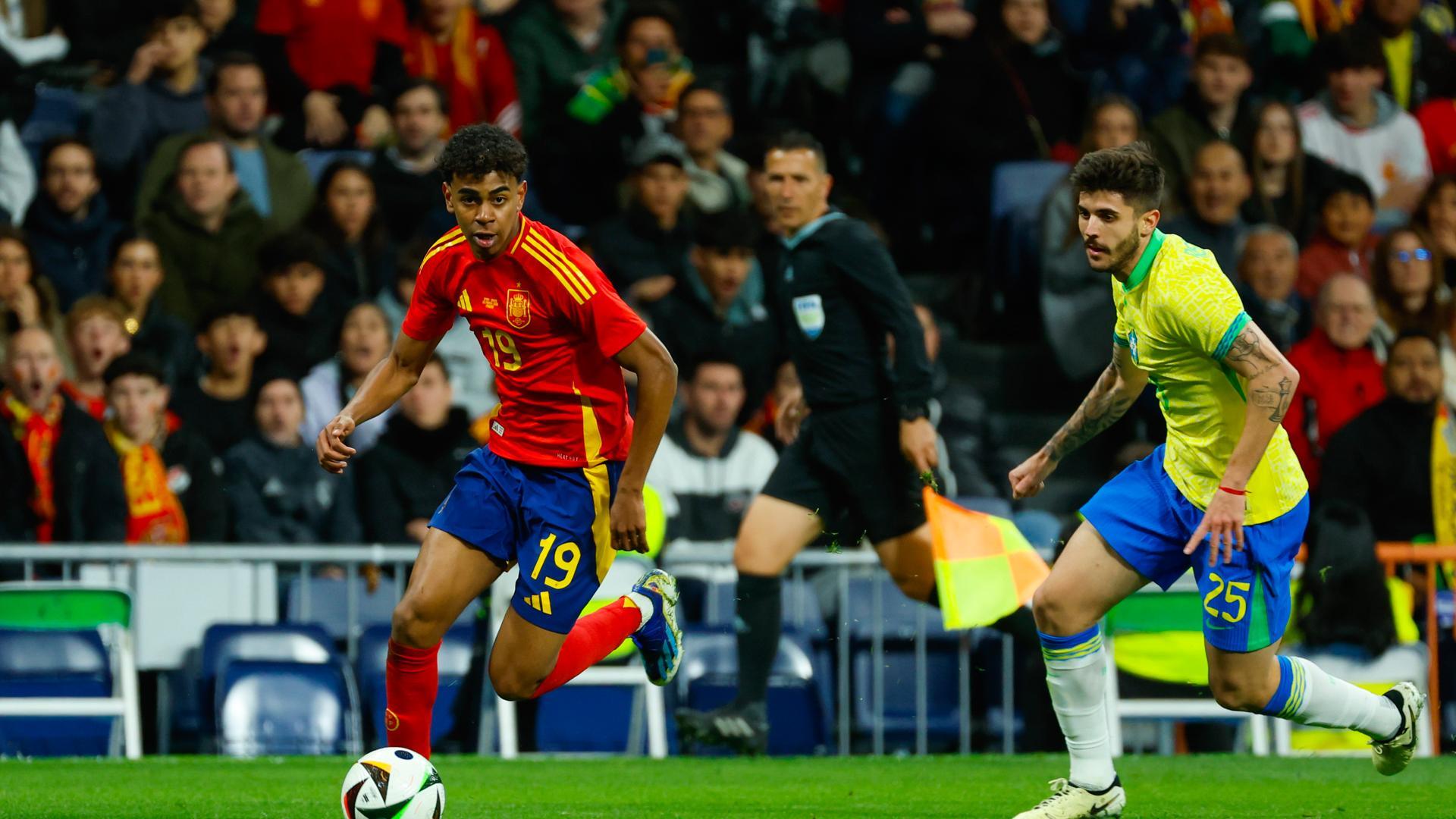 El delantero de la selección española Lamine Yamal (i) disputa un balón frente a Lucas Beraldo, defensa de la selección brasileña