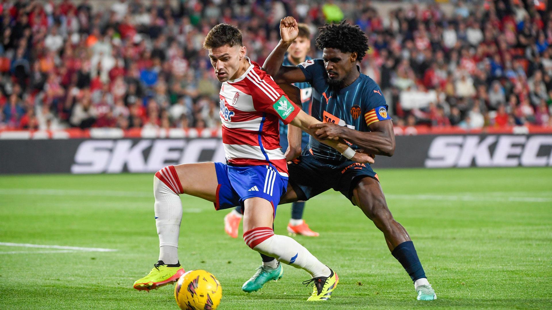 El delantero argentino del Granada Lucas(i) pelea un balón con el defensa portugués del Valencia Thierry Correia (d) durante el partido de LaLiga entre Granada CF y Valencia CF
