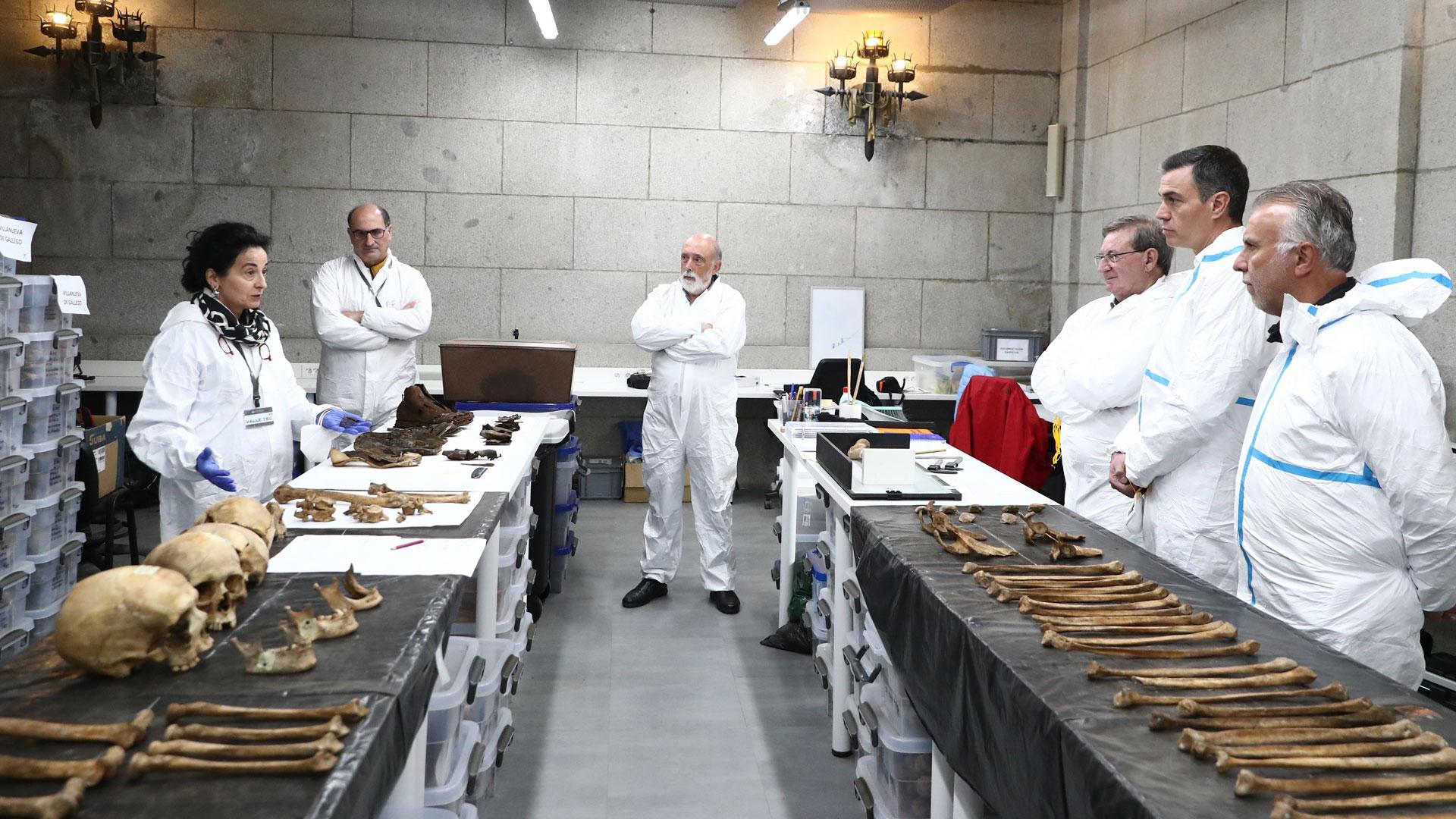 El presidente del Gobierno, Pedro Sánchez (2d), durante su visita este jueves el Valle de Cuelgamuros para conocer sobre el terreno las tareas que se realizan para la recuperación e identificación de 160 víctimas del franquismo reclamadas por sus familias