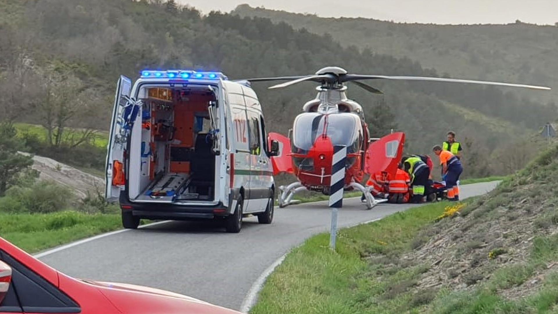 Agentes de la Policía Foral junto al helicóptero que trasladó a uno de los motoristas accdentados este domingo./