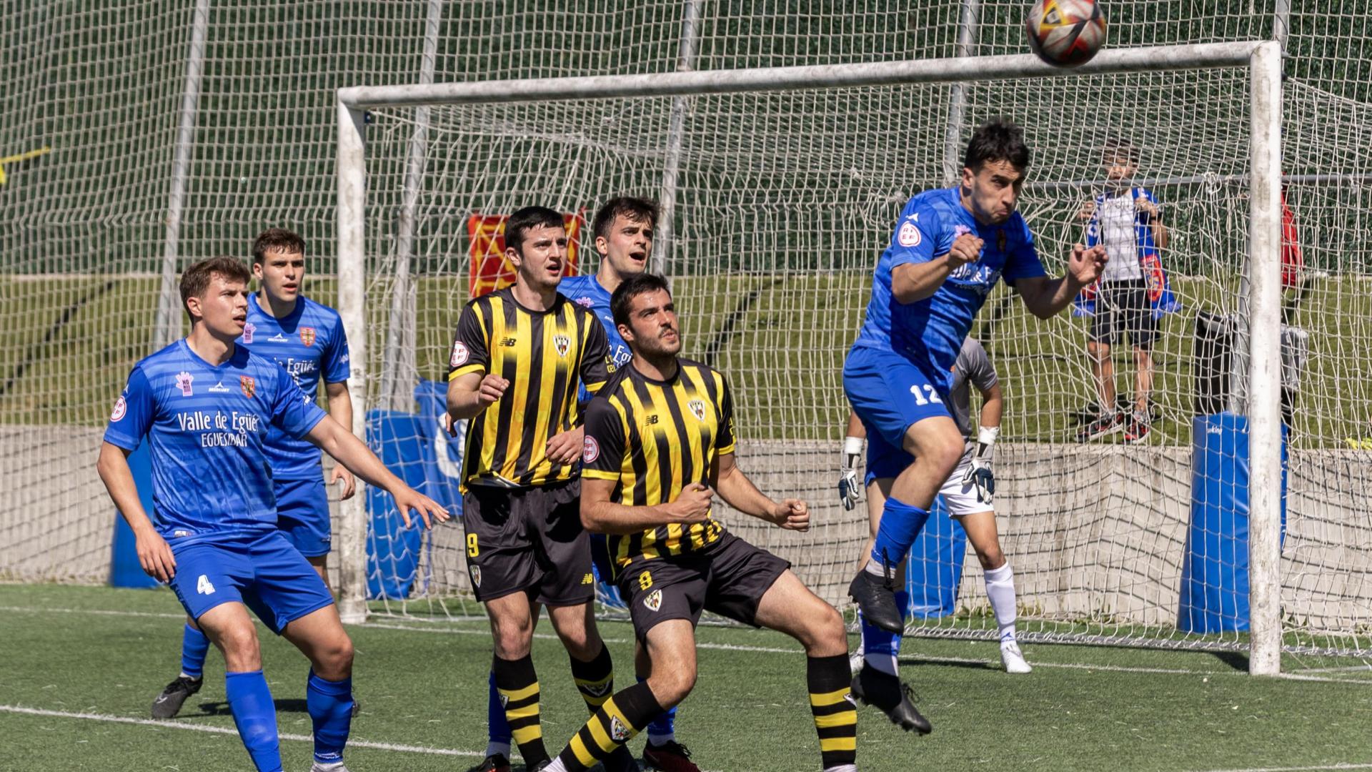 Astráin despeja el balón con la cabeza dentro del área.