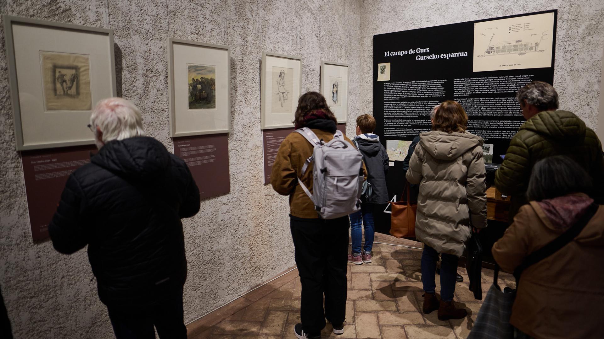 Varias personas contemplan las obras realizadas por artistas internados en el Campo de Gurs. La muestra se puede visitar en el patio del Condestable