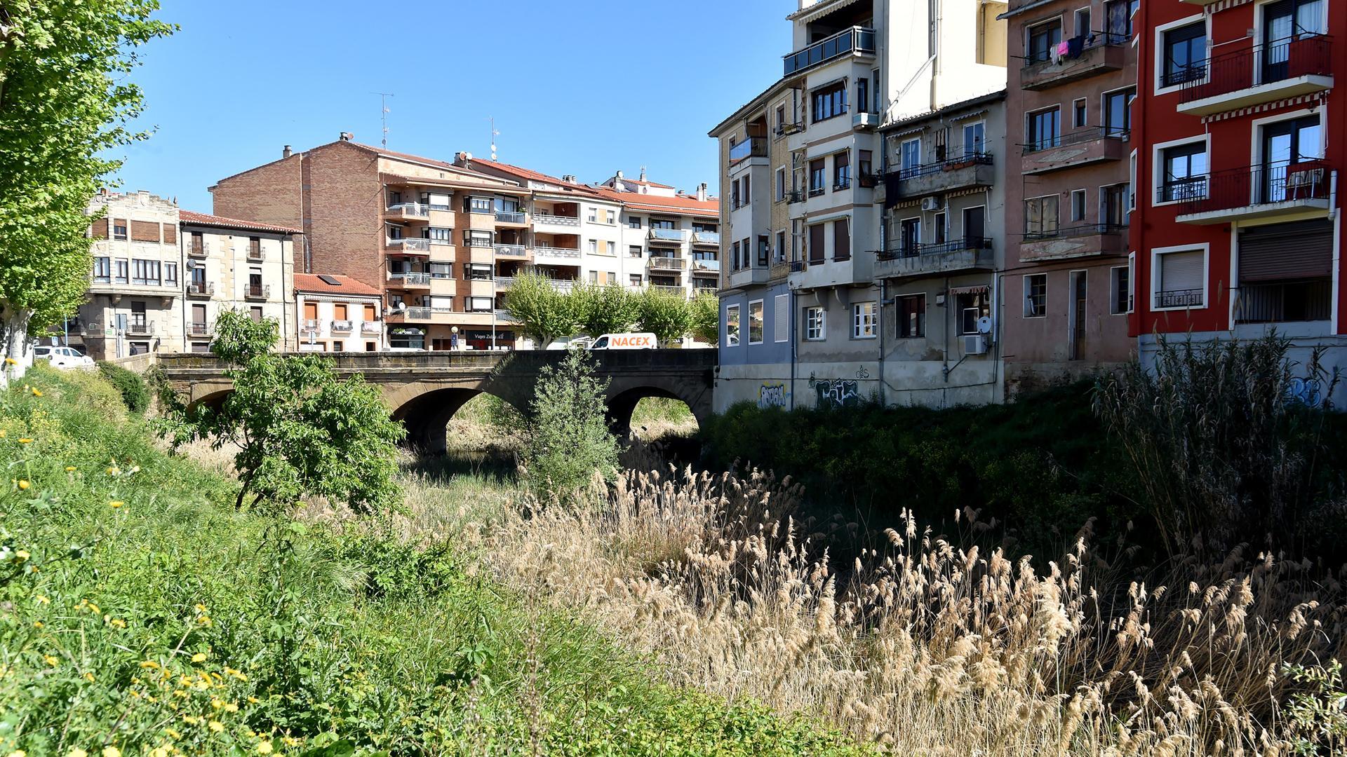 Vista del cauce del río Cidacos, completamente cubierto, con el puente al fondo
