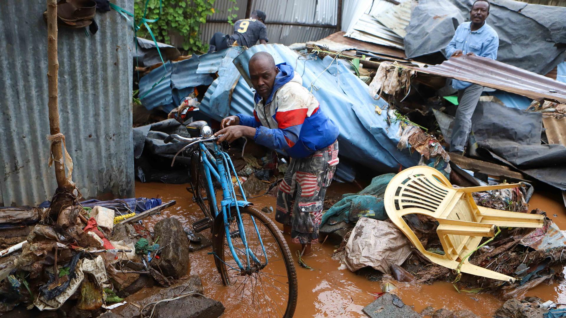 Un hombre intenta recuperar parte de sus posesiones tras las lluvias torrenciales en el barrio de Matare, situado en la capital de Kenia