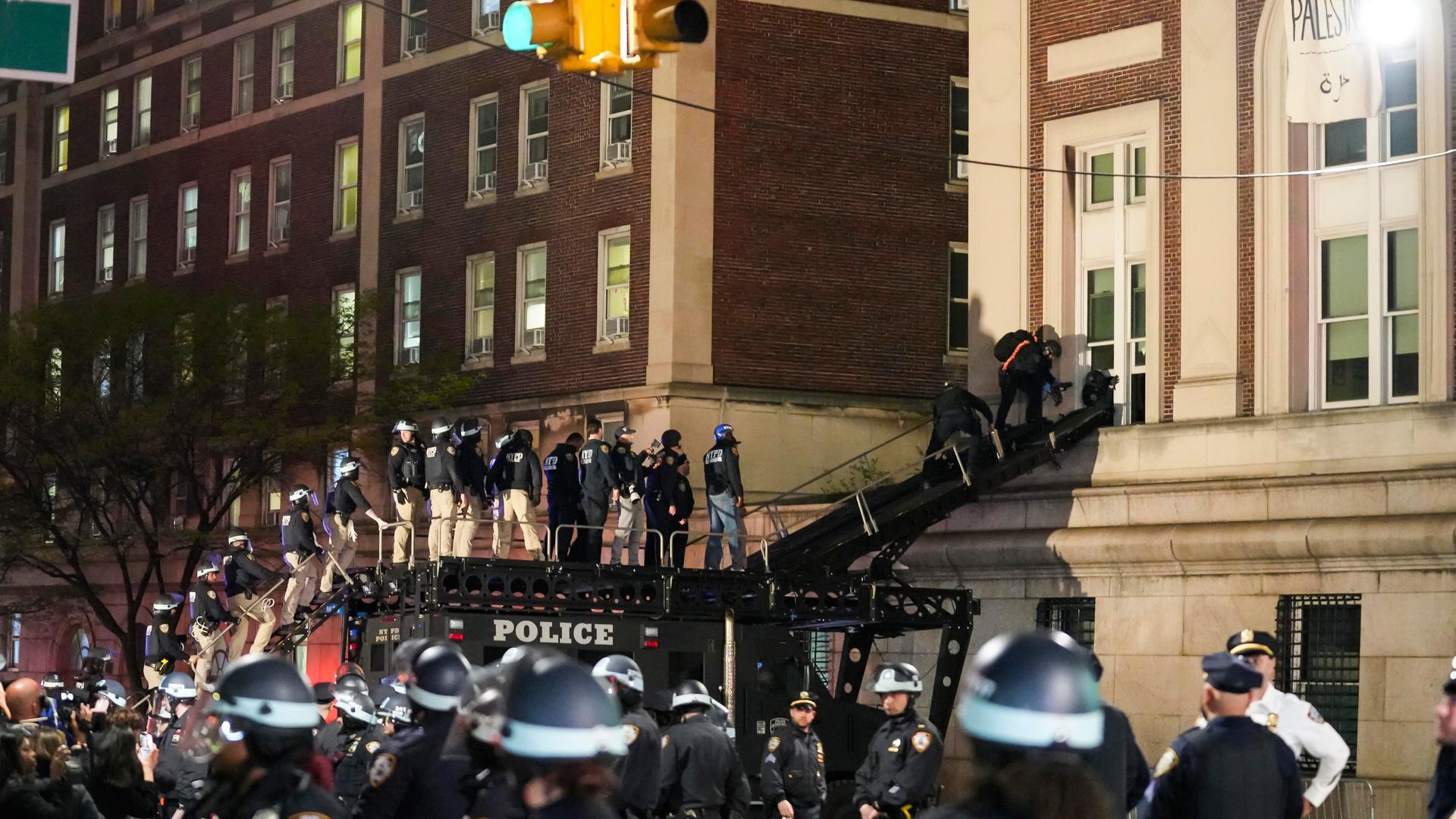 Policías de Nueva York acceden por una escalera de bomberos a uno de los edificios de la Universidad de Columbia