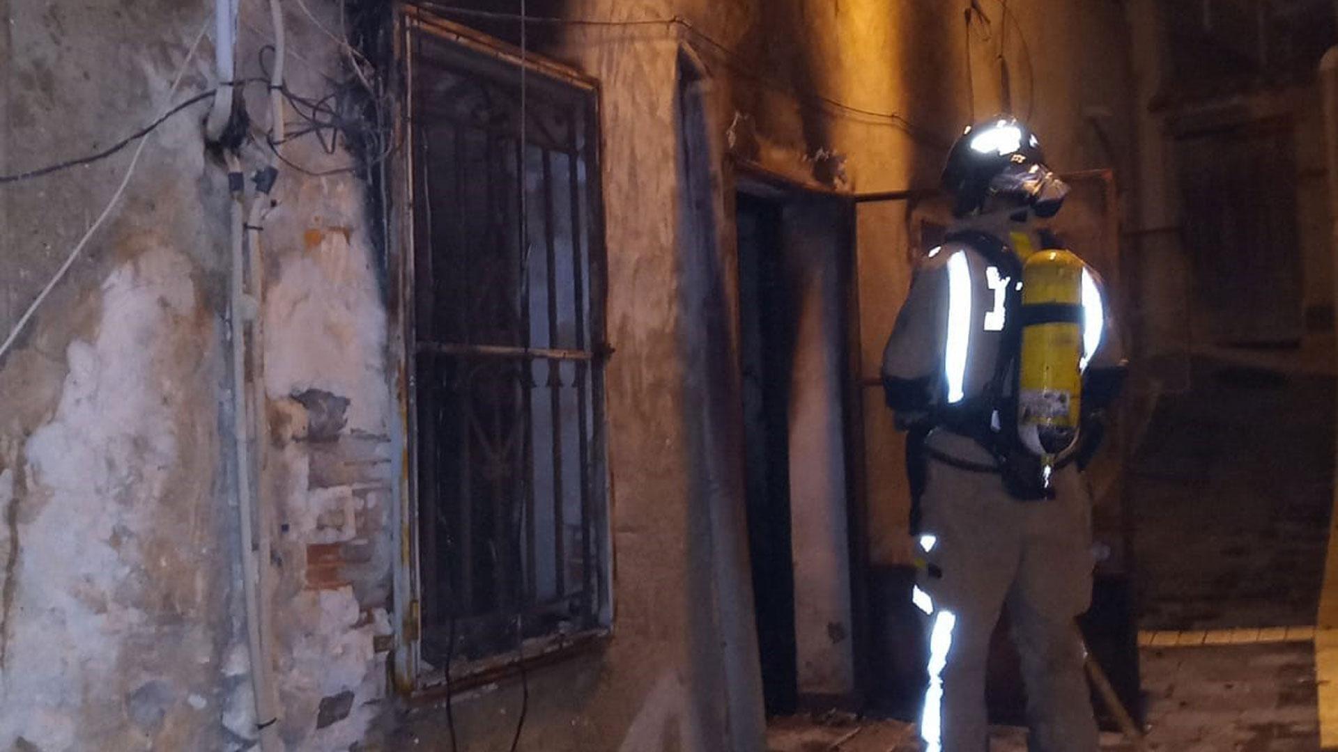 Un bombero inspecciona la casa incendiada en Ricote (Murcia) en la que han fallecido tres personas