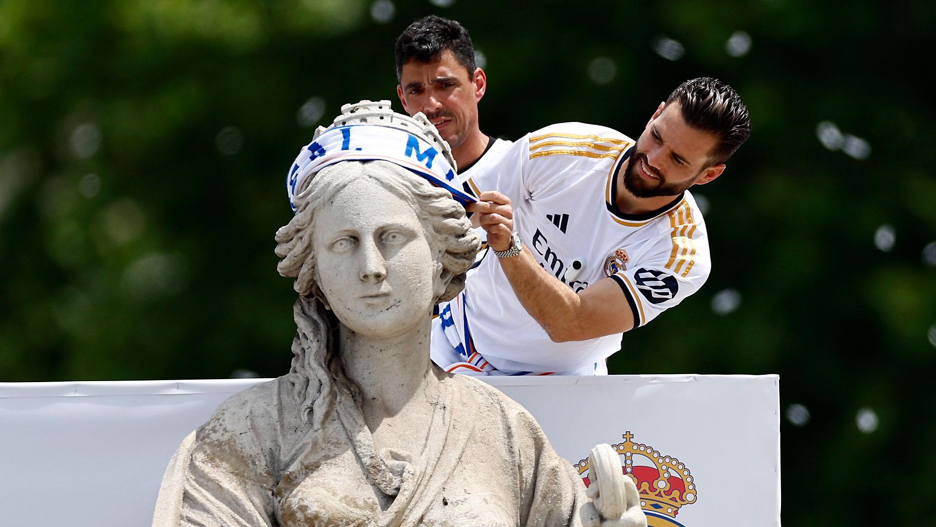 El capitán del Real Madrid, Nacho Fernández, coloca una bufanda a la diosa Cibeles durante la celebración con aficionados de la Liga número 36