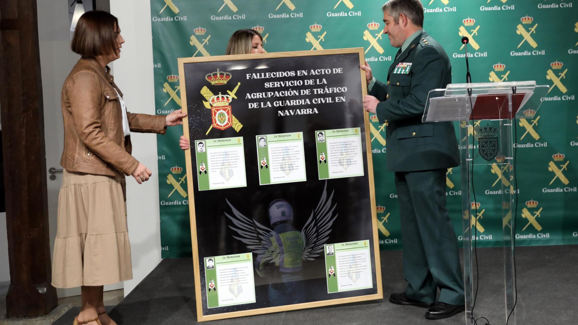El teniente coronel jefe de Tráfico, Agustín Aznárez, entrega a Sarai Rodríguez un cuadro homenaje con los agentes de Tráfico fallecidos en Navarra