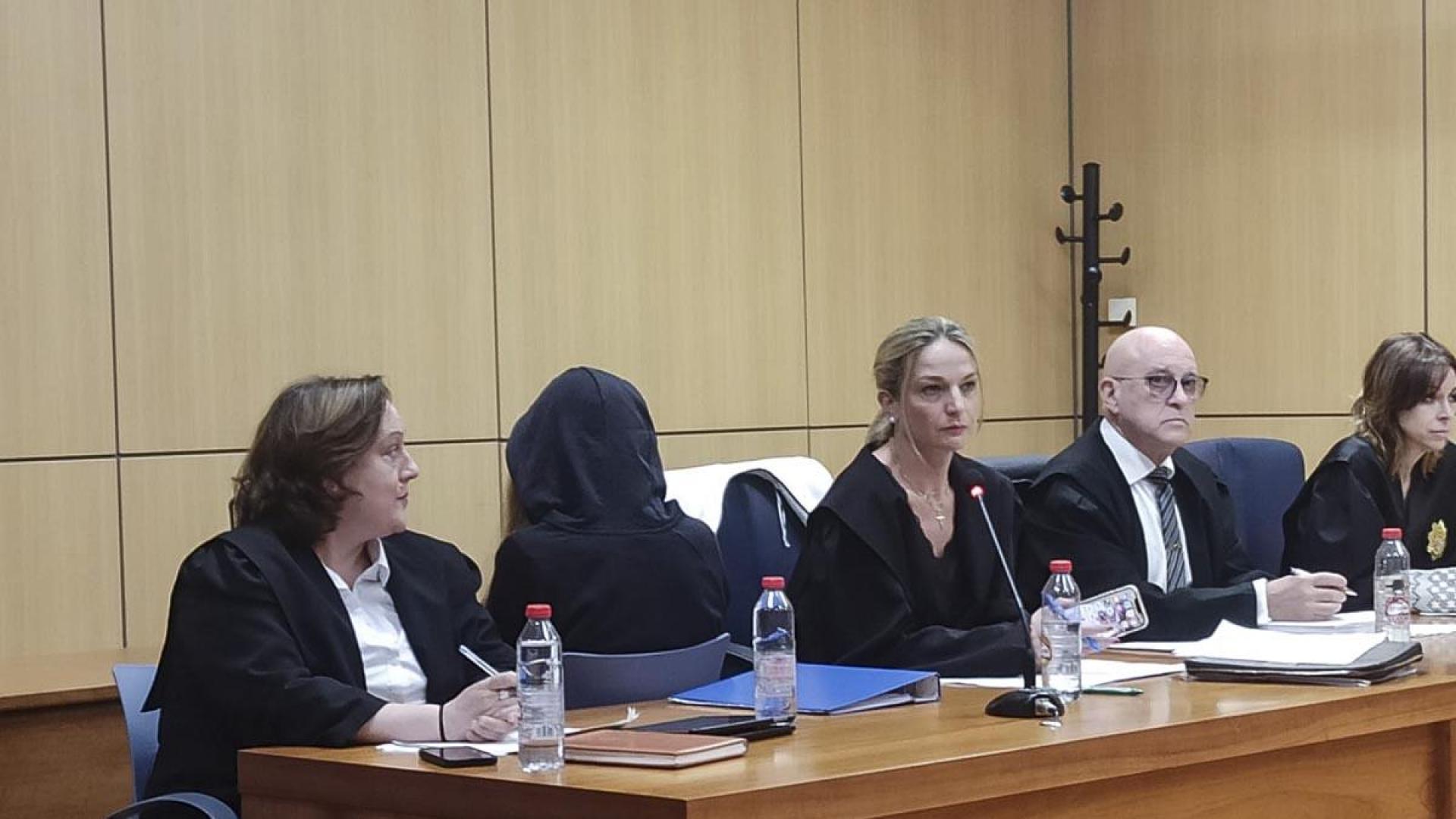 En la imagen sentada de espaldas, la joven acusada de matar a su madre el 1 de abril de 2020 en la casa de l'Alcúdia de Crespins