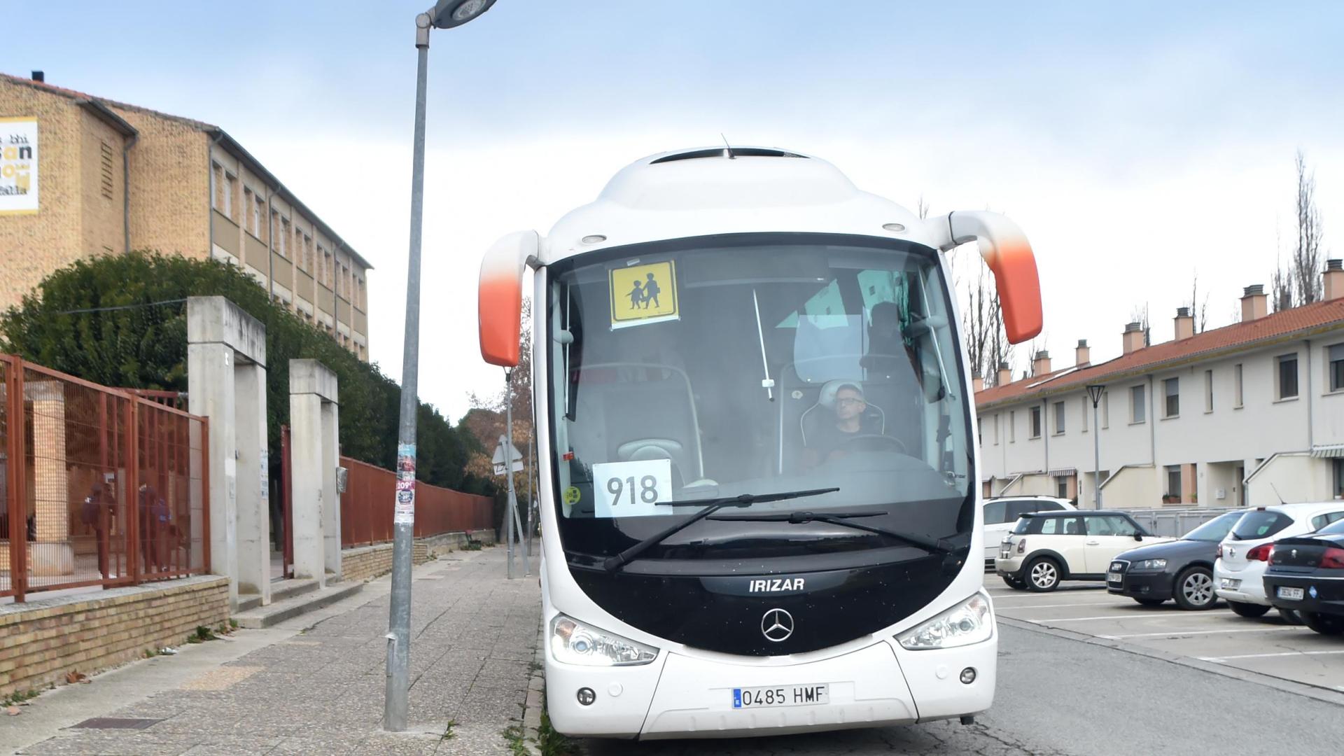 Un autobús escolar en la puerta del instituto sobre el firme en el que se aprecian varias grietas.