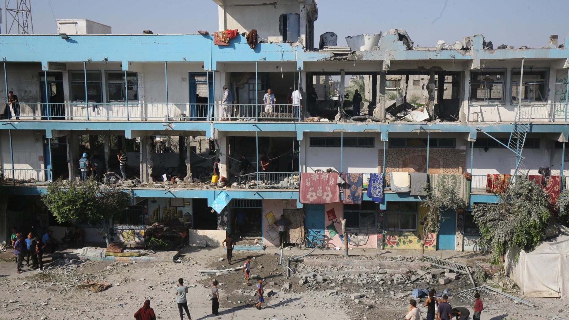 Palestinos en una escuela de la Agencia de Naciones Unidas para los Refugiados de Palestina en Oriente Próximo (UNRWA) bombardeada por el Ejército de Israel en el campamento de refugiados de Nuseirat, en el centro de la Franja de Gaza