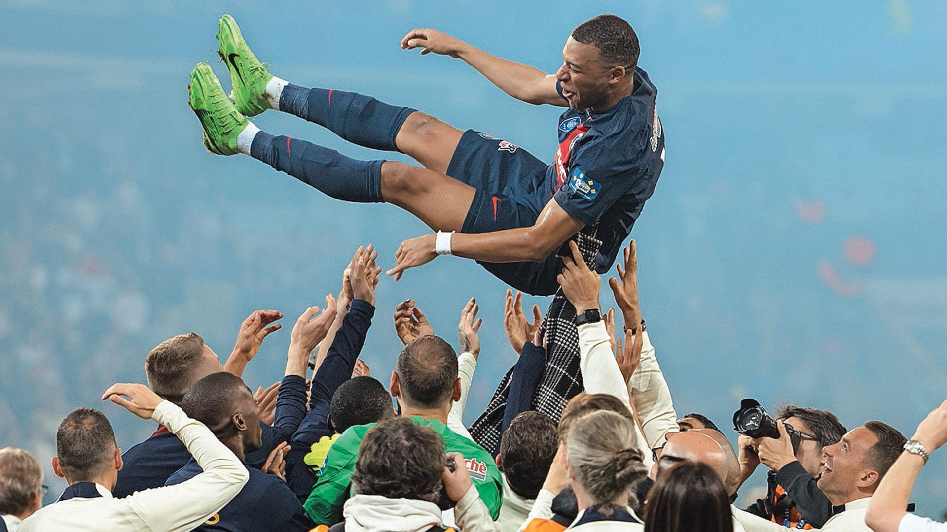 Mbappé manteado por sus compañeros del PSG en el último partido de la liga francesa en Lyon