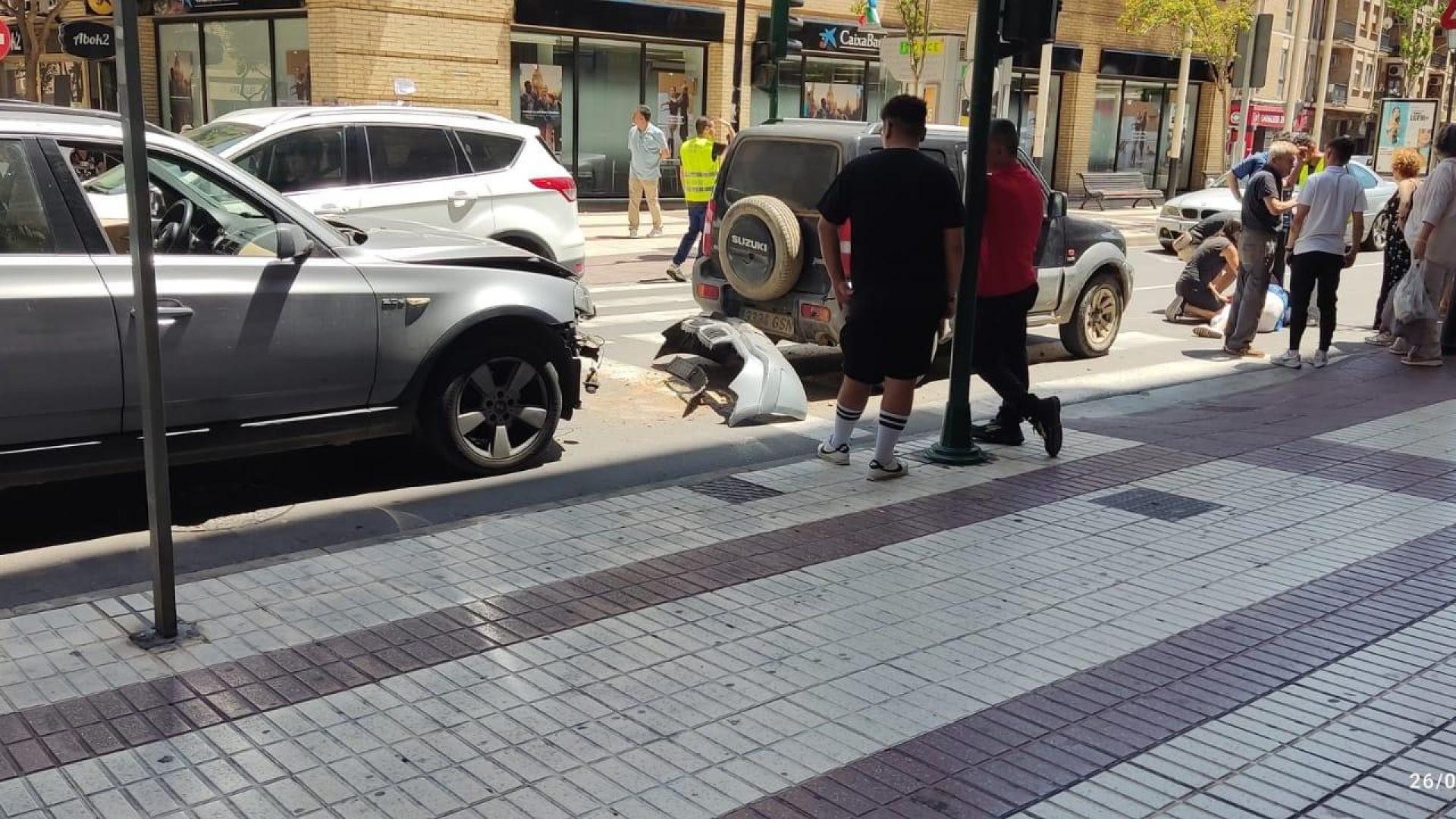 Los dos vehículos implicados y la mujer, sobre el suelo, tras el atropello