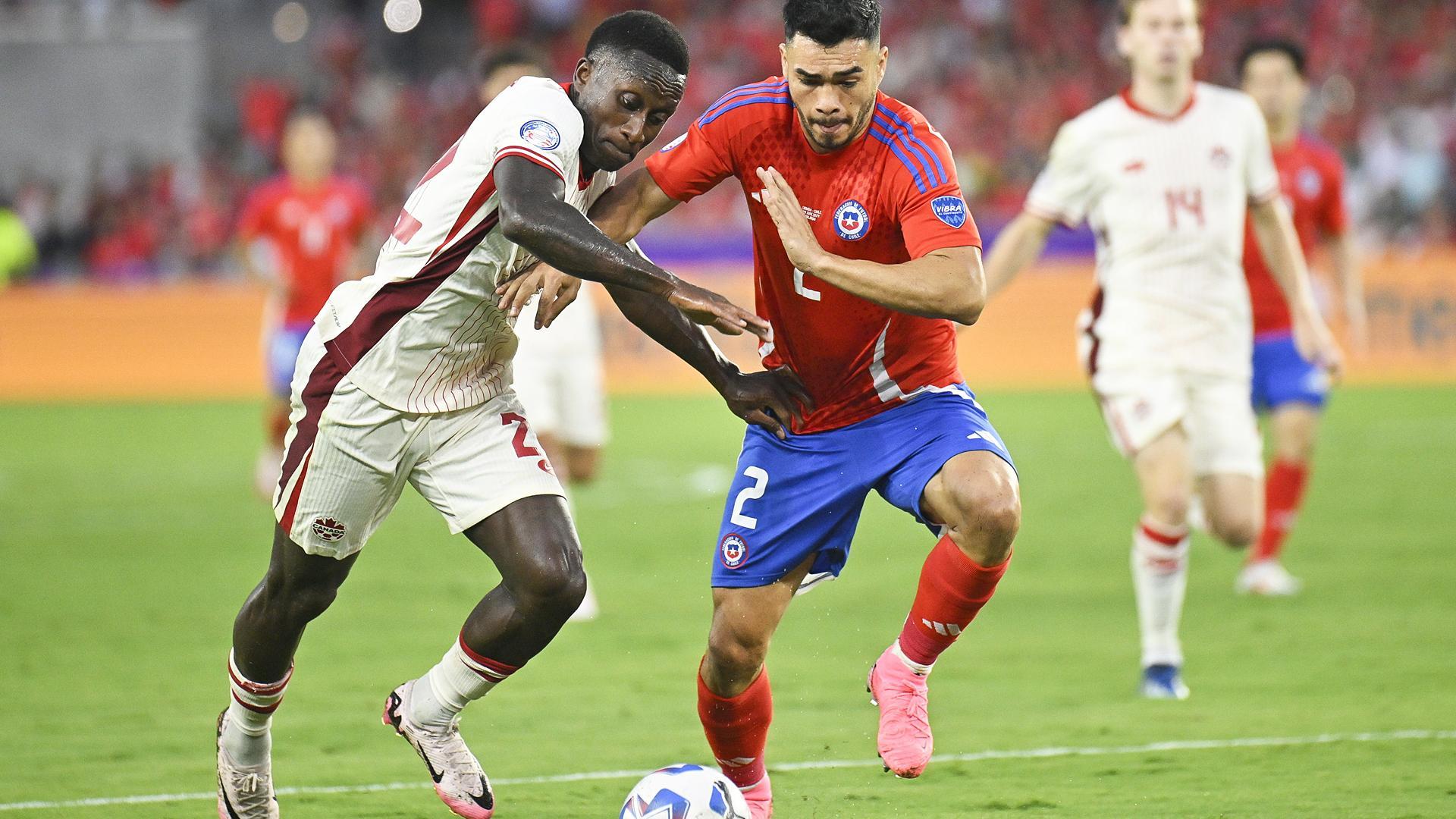 El canadiense Richie Laryea (izda.) trata de marcharse del chileno Gabriel Suazo, que fue expulsado, en un momento del encuentro