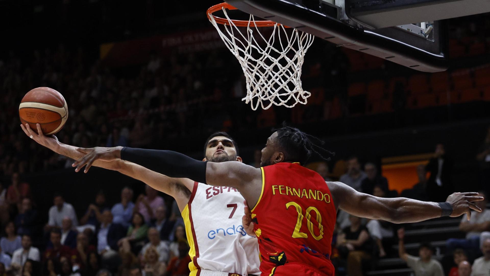 El escolta de la selección española, Santiago Aldama, trata de encestar ante la oposición del pívot de Angola, Bruno Fernando (d)