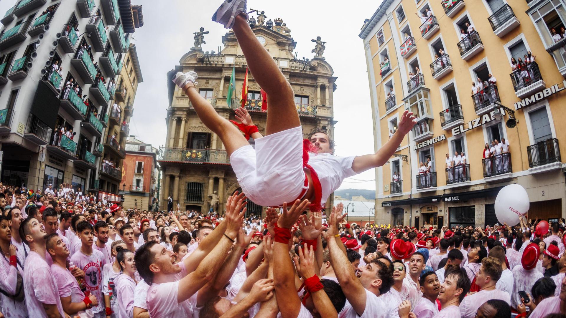 Varios mozos airean a otro poco antes del Chupinazo este 6 de julio.