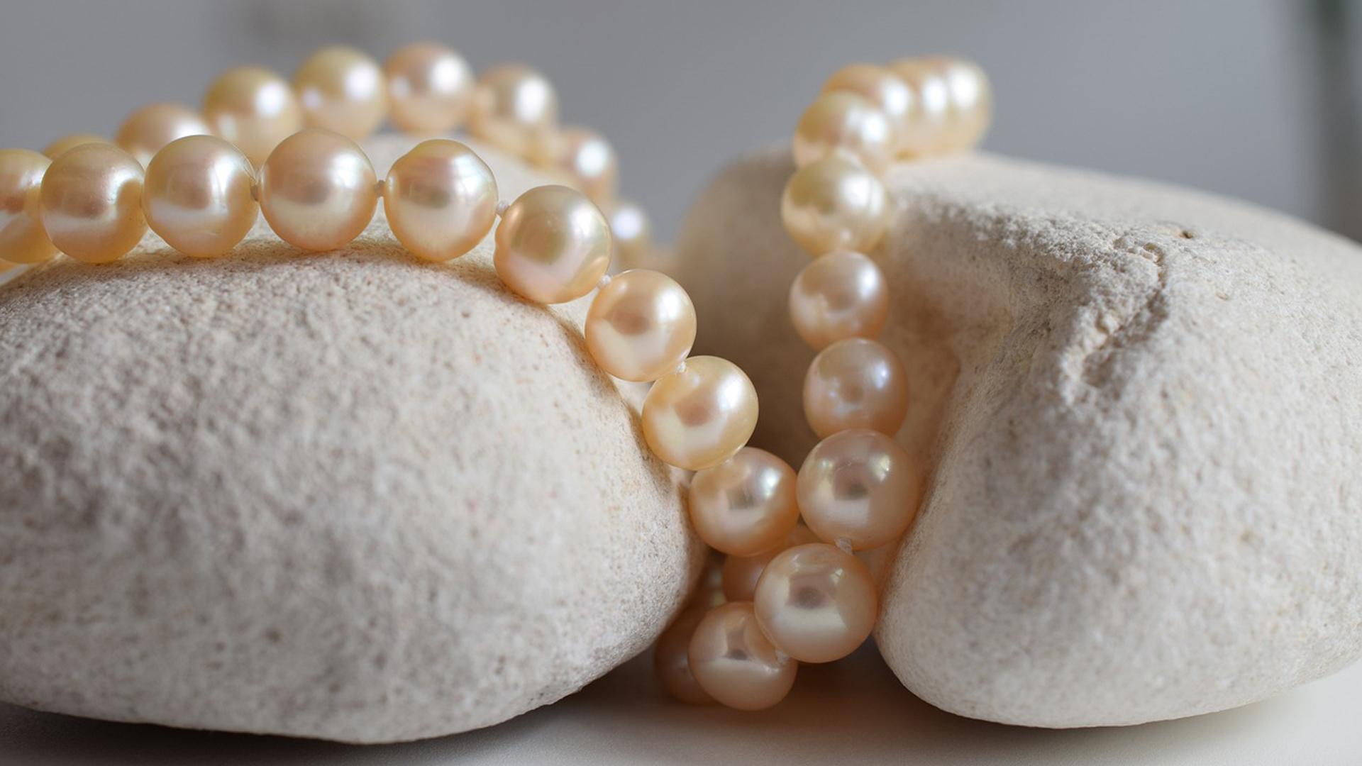 Un collar de perlas acomodado en una piedra